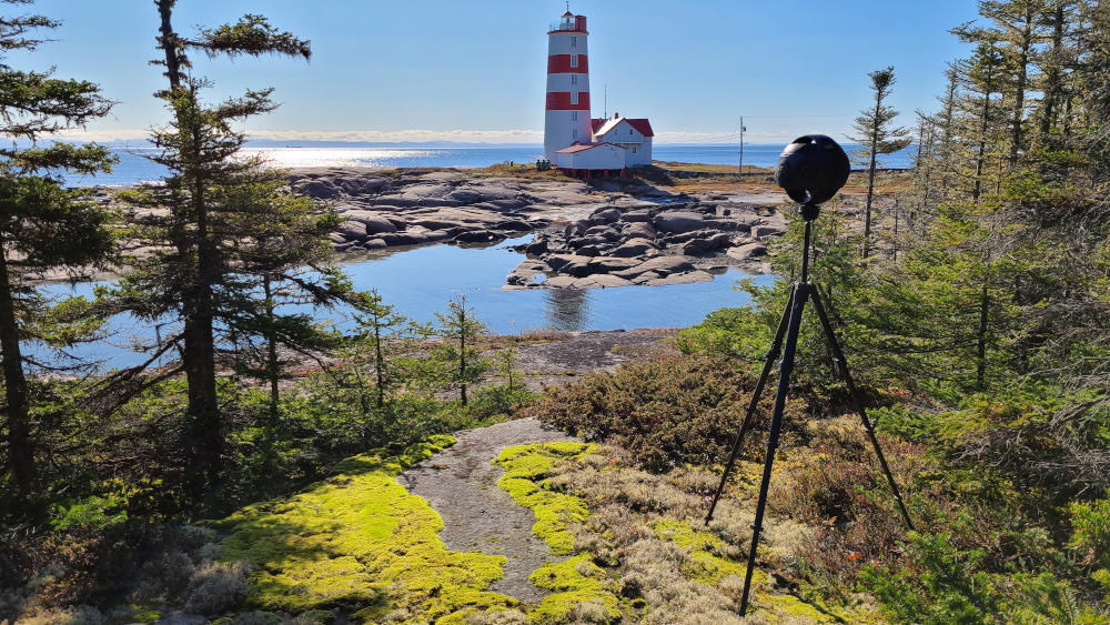 Insta360 Titan surrounded by trees with a view of a lighthouse. Shooting for the immersive virtual reality experience.