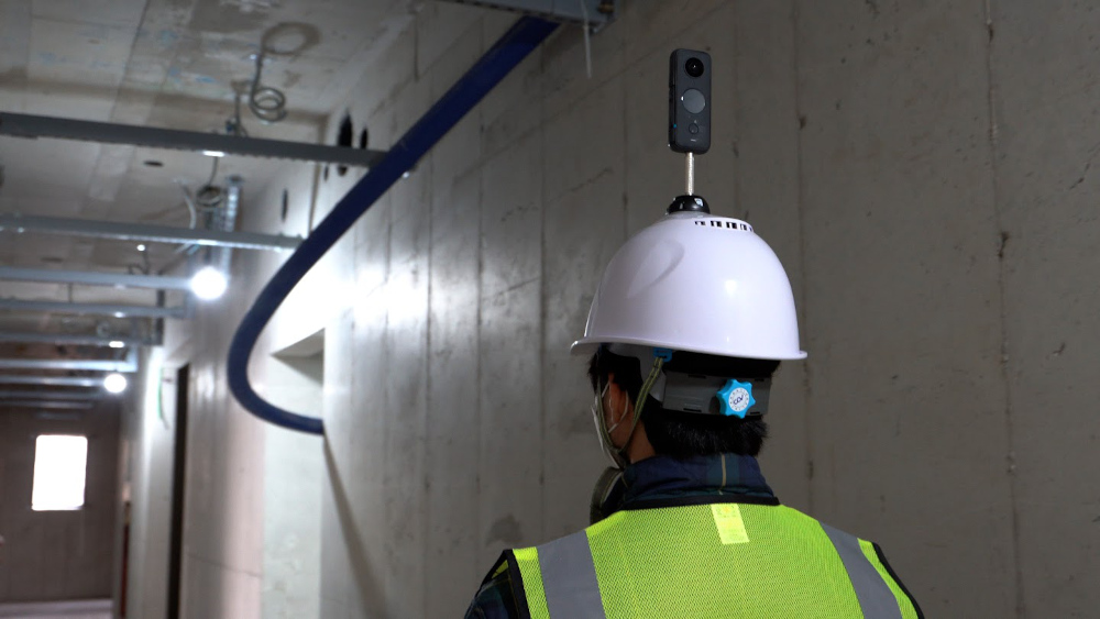 Insta360 ONE X2 camera mounted to a construction worker's hardhat 