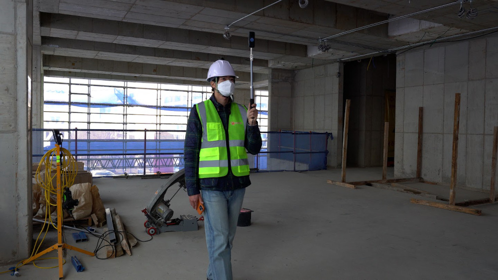 Construction worker capturing 3D digital twin using Cupix software and Insta360 ONE X2