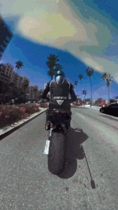 Gif di un motociclista che guida in strada con gli effetti IA che cambiano continuamente il colore del cielo. Riprendi con Insta360 X3.