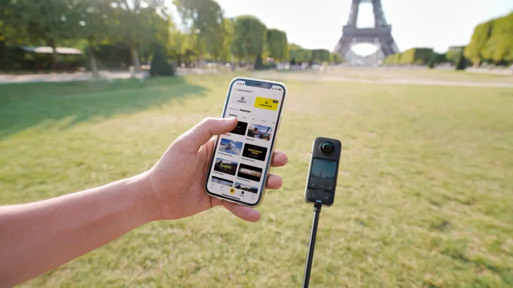 Insta360 X3 e qualcuno che utilizza l'app Insta360 sul proprio smartphone, con la Torre Eiffel sullo sfondo.