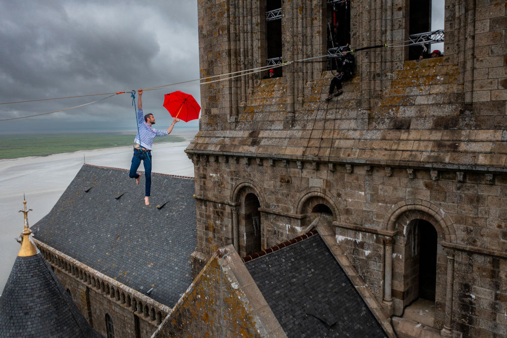 Nathan Paulin poses with an umbrella while highlining, France 2022