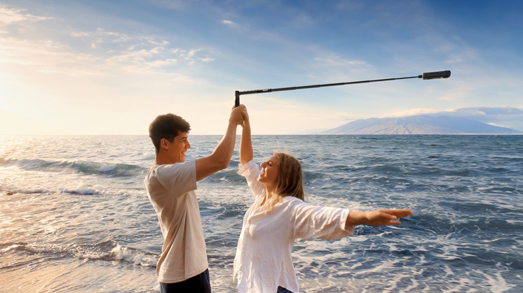 One man and one woman are taking the bullet time shot near the sea.