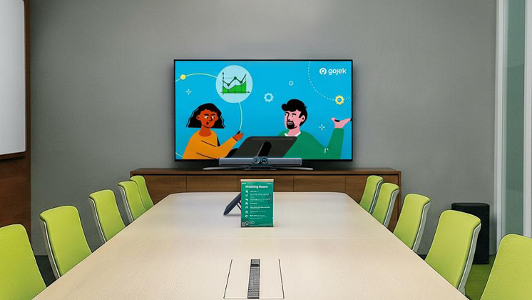An empty meeting room with an Insta360 Connect videobar placed under a TV.