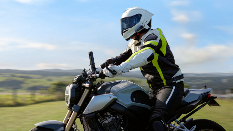 Man riding a motorcycle in the country recording his ride using Insta360 X5 with Heavy Duty Clamp and Action Invisible Selfie Stick accessories