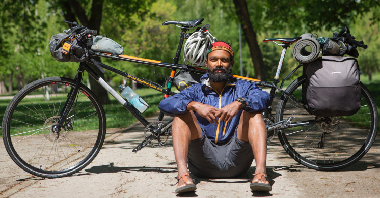 Kumar sitting in front of his tandem bike.