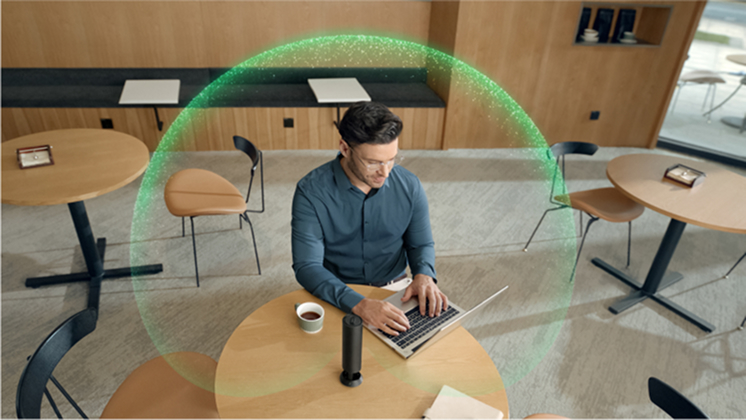 A man works at his desk while Insta360 Wave works to filter out background noise.