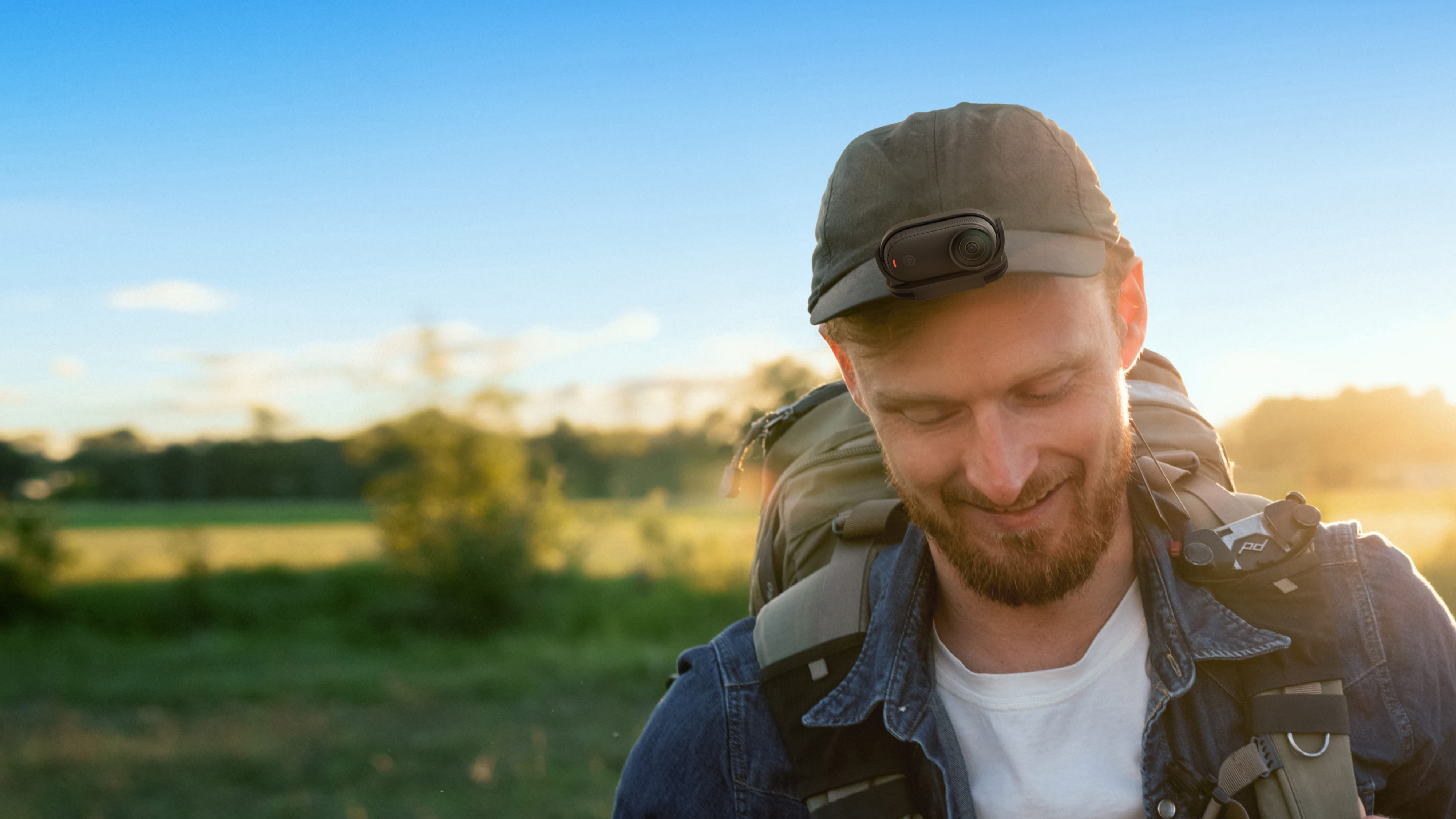 A shot of a hiker using Easy Clip to attach a GO 3S to his hat.