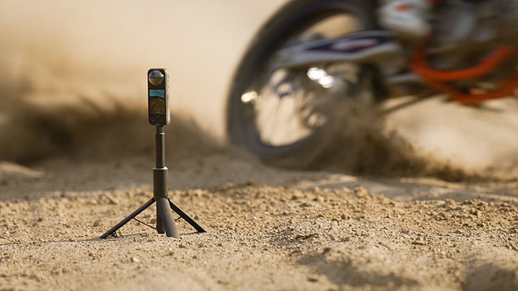 An Insta360 X4 mounted on a tripod to capture dirt bike action