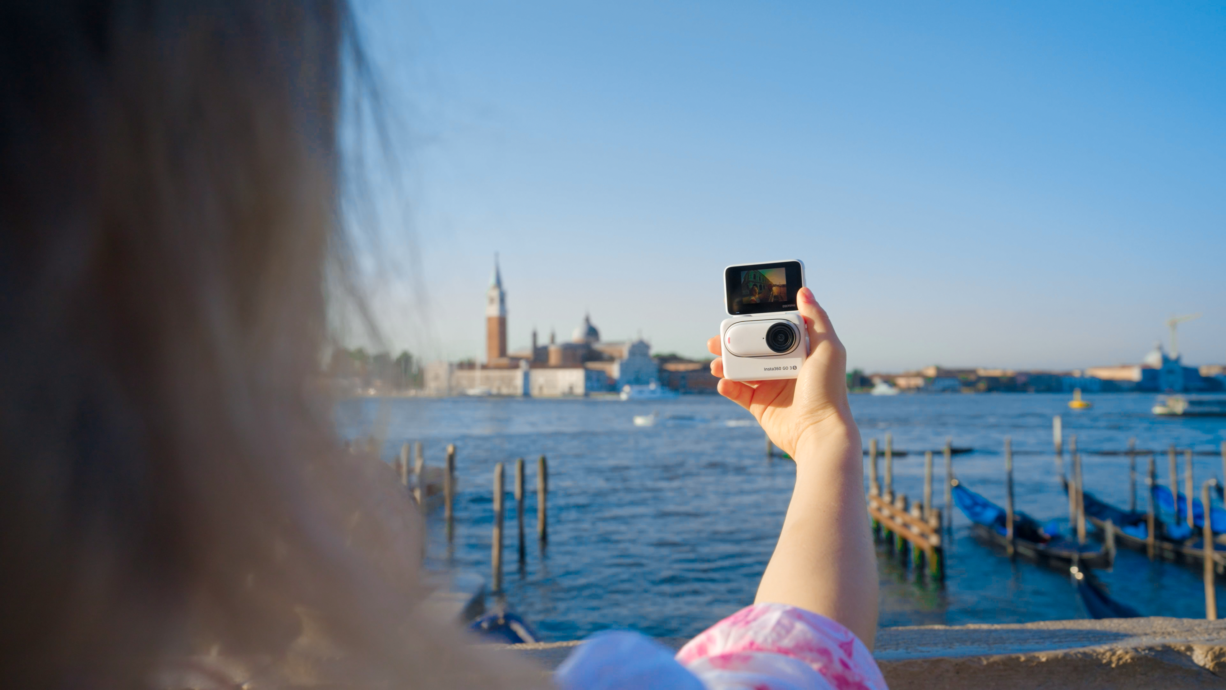 A shot of a woman vlogging in Italy with a GO 3S in the Action Pod.