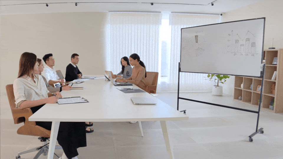 A meeting room discussion that utilizes a whiteboard diagram