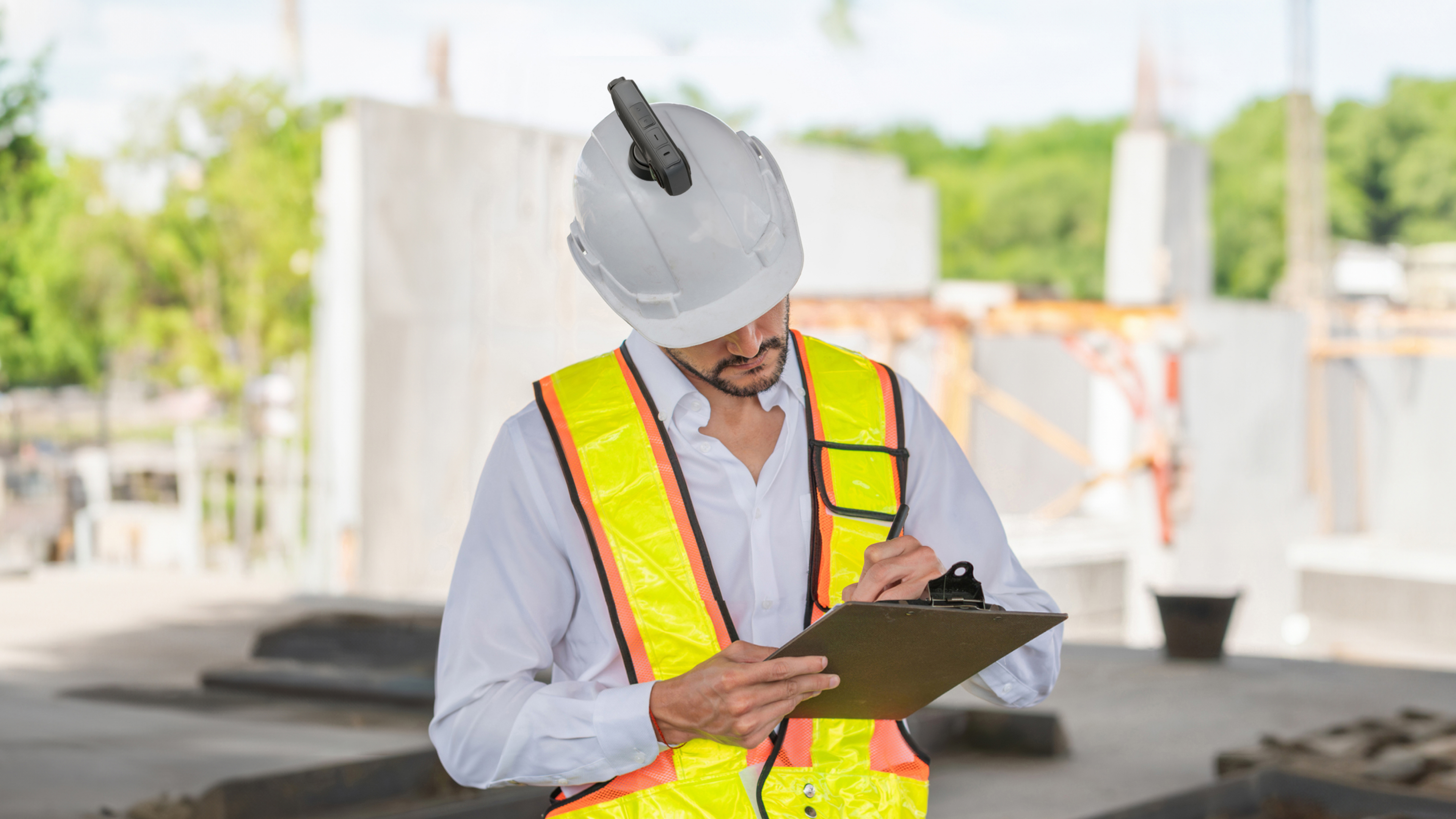 A construction site worker in a yellow high-vis with Insta360 X4 mounted onto his hard hat.