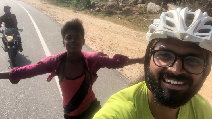 Kumar with a boy riding on the back of his tandem bicycle