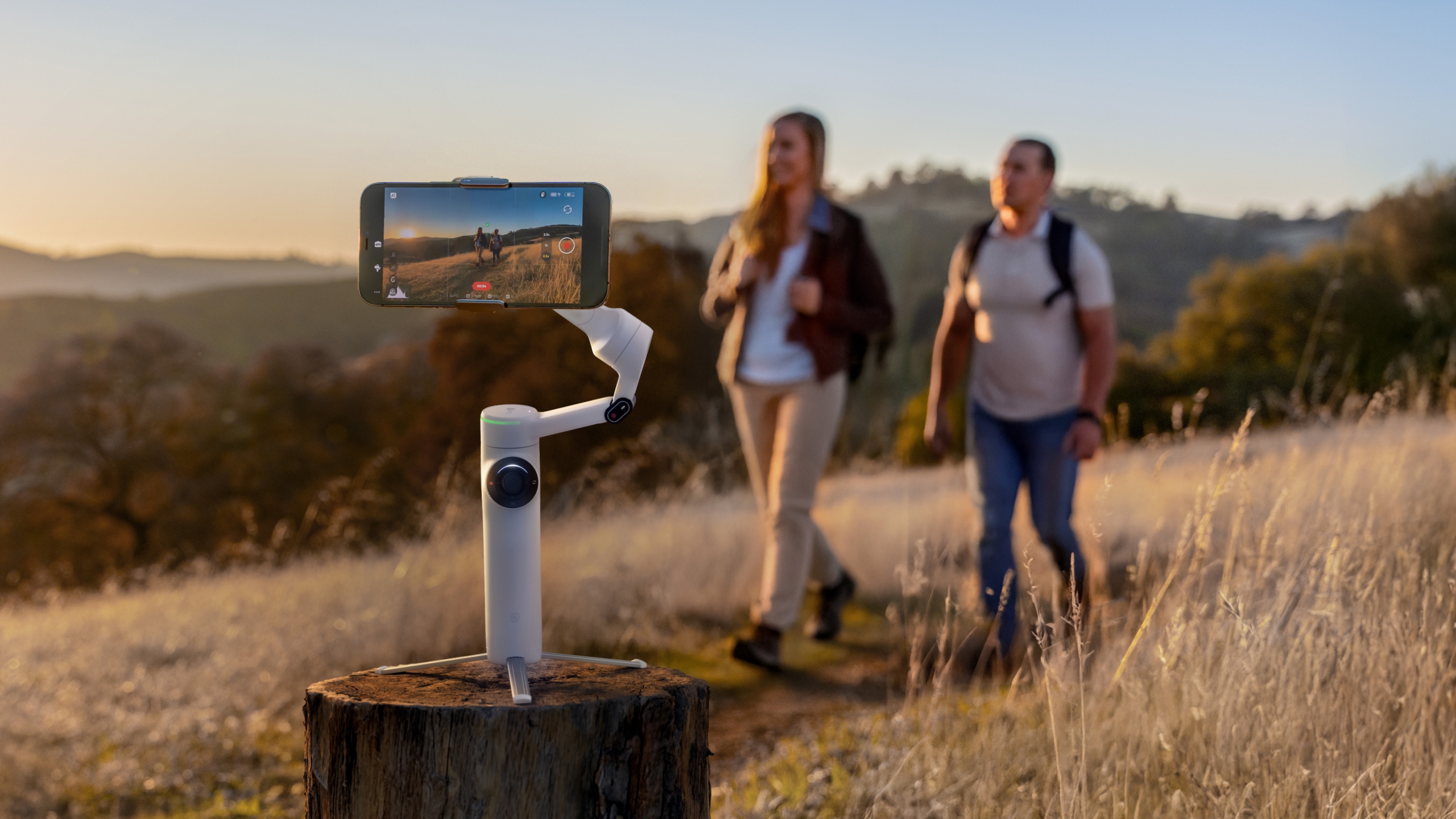 Zwei Wanderer, die in einem Feld wandern und von der Insta360 Flow 2 Pro aufgezeichnet und verfolgt werden.