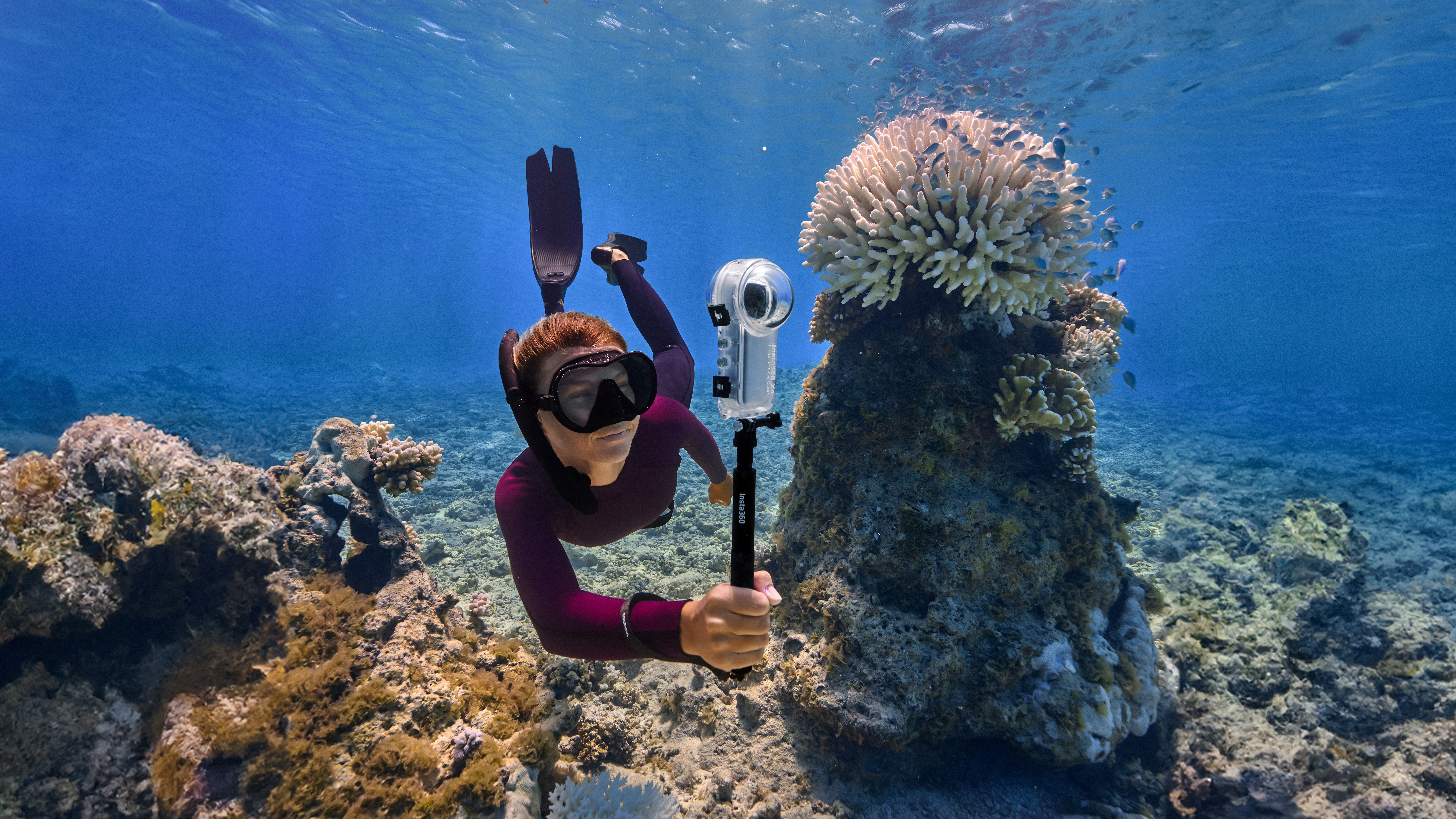 A diver swimming with Insta360 X4 in the Invisible Dive Case.