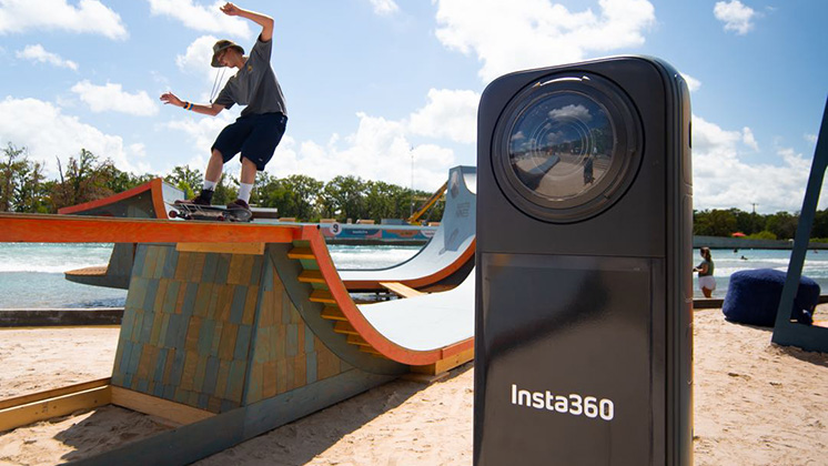 A skater slides on a skateboard ramp with a massive Insta360 X4 mockup next to him.