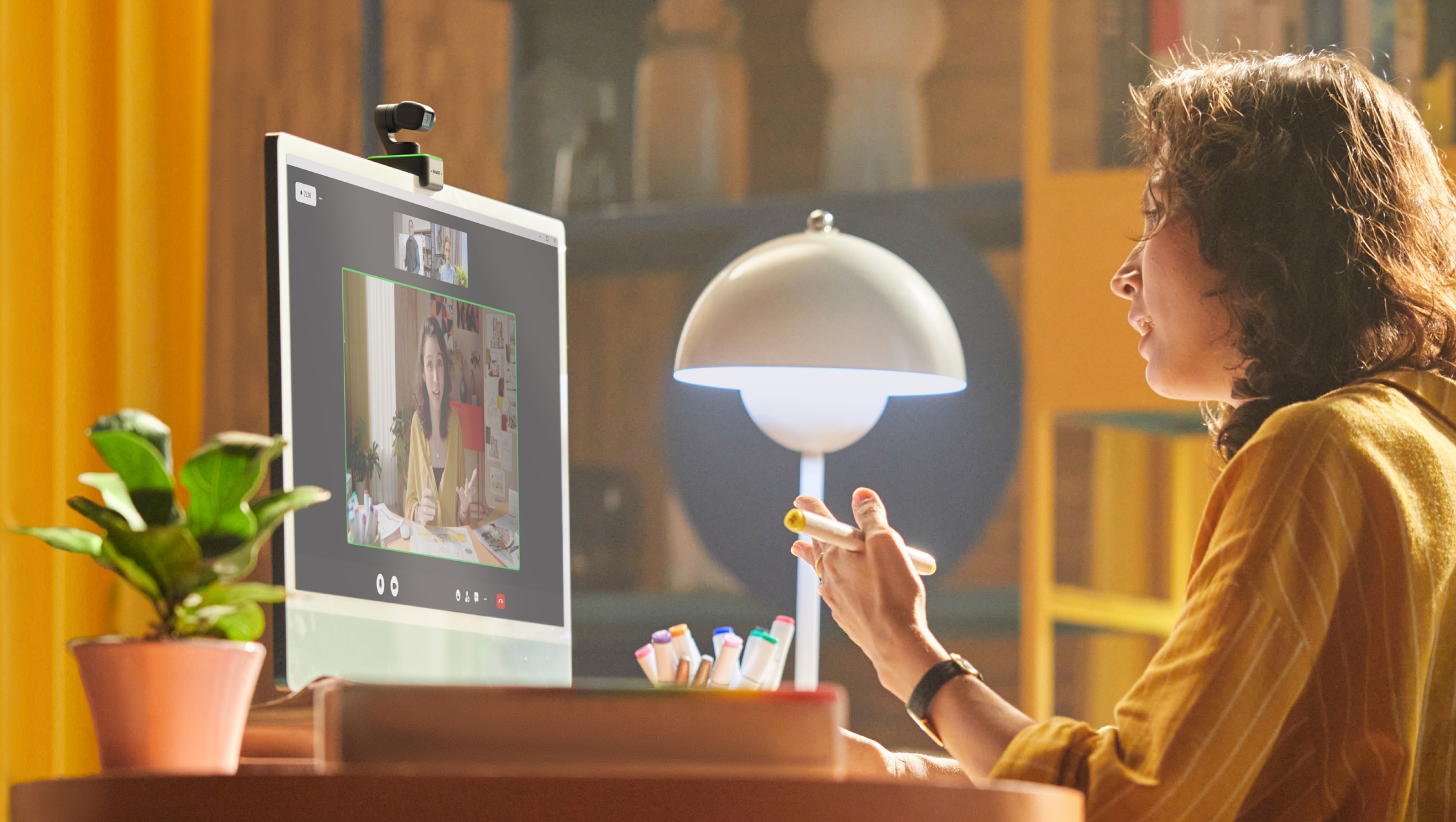 Das Bild zeigt eine Frau vor einem iMac, auf dem eine Insta360 Link montiert ist.